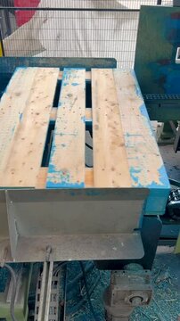 Robotic arm carefully fixing wooden pallets, demonstrating precise automated manufacturing inside modern industrial facility