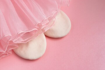 Soft pink tutu and ballet slippers on a pink background, symbolizing dance, childhood and dreams.