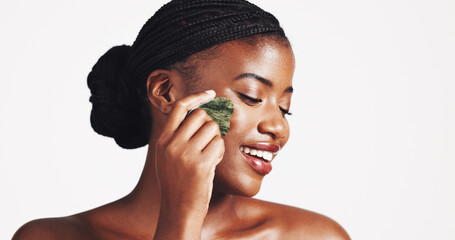 Cosmetics, skincare and black woman with gua sha in studio for lymphatic drainage, natural beauty...