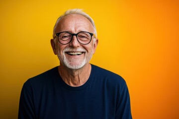 Obraz premium Senior man with glasses smiles warmly on bold background
