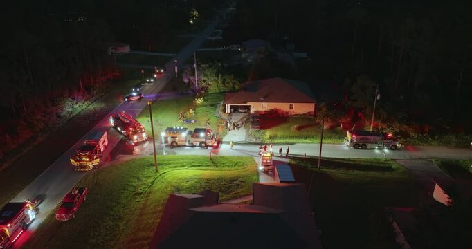 First responders investigating fire hazard of private house at night. Emergency service personnel responding to carbon monoxide accident on Florida residential street.