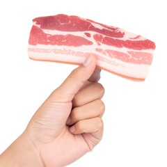 Raw pork belly held by hand against black background