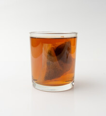 Herbal tea sachet in glass, hot water with chamomile and Hypericum or St. John's wort teabag