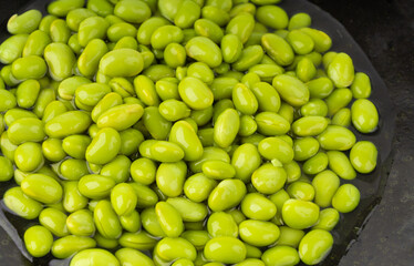 Edamame beans bowl textured background. Green soy bean pattern, many cooked young soybeans