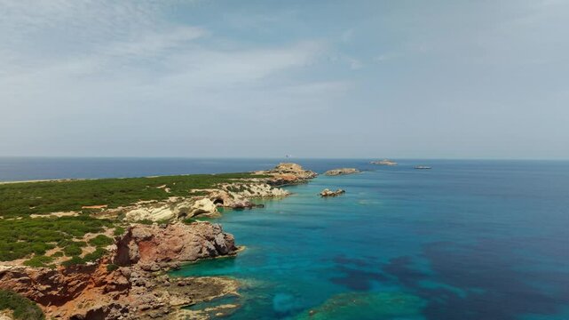 Cinematic drone clip of Zafer Burnu with two national flags flying above the Mediterranean coast in Northern Cyprus, capturing culture and geography.