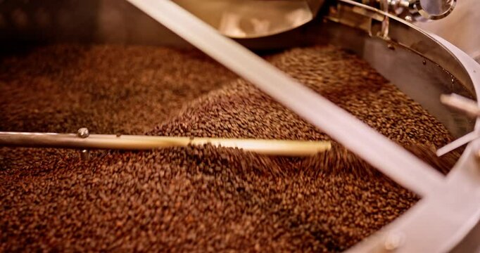 Roasted beans rotate in a metallic cooling drum during a smooth slider shot.