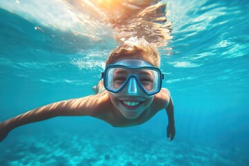 Naklejka premium Young boy snorkeling underwater in bright sea