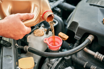 Oil being poured into vehicle engine
