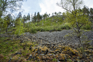 A beautiful and scenic rocky outcrop, majestically surrounded by lush greenery, sits peacefully in a serene landscape that invites exploration and adventure, showcasing natures incredible beauty