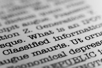 Classified information. Text printed on a page. A piece of paper with a phrase written in retro...