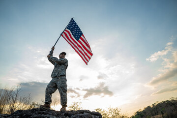 Hand Waving the Flag of the United States of America in memorial day . Us soldier holding American...