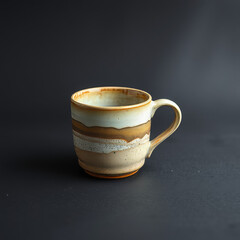 handmade Ceramic Coffee Mug with Earth Tone Glaze on Dark Background
