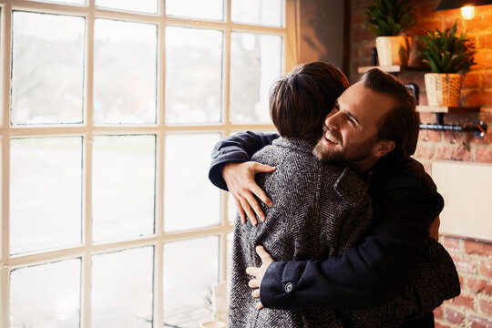Couple embracing and greeting each other in a London coffee shop