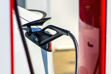 Detail of a connected charging station for a electric car. Charging an electric car at an outdoor charging station.