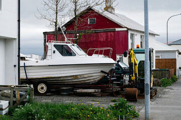 Small boat and excavator outside a colorful house in Akranes, Iceland
