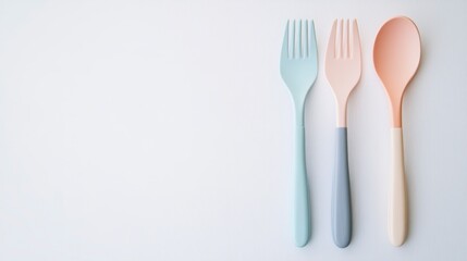 Pastel-colored plastic fork and spoons on white background.