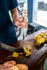  the preparation of Empal Gentong, a Cirebon beef soup. A vendor is cutting freshly cooked meat. The scene is bustling and aromatic