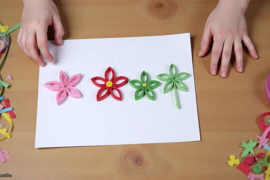 child is making a quilled heart on a piece of paper