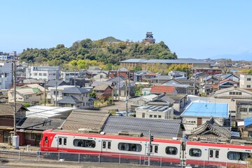犬山市、国宝犬山城をバックに走る名鉄電車