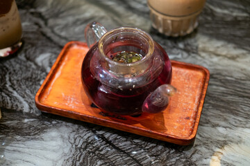 a glass teapot containing herbal tea, a common beverage in many Asian cultures. The tea appears to...