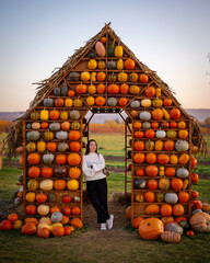 Woman Near Decorative Pumpkin House
