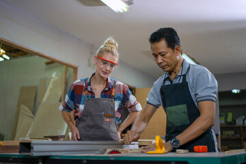Carpenters are working together at workshop.