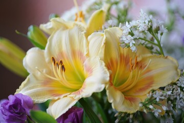 Bright yellow lilies surrounded by delicate white and purple flowers in a bouquet setting