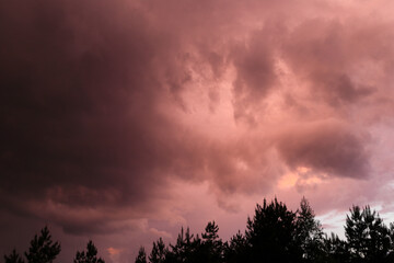 Fiery red storm clouds with dramatic lighting. Red storm clouds background. Dramatic red sky.