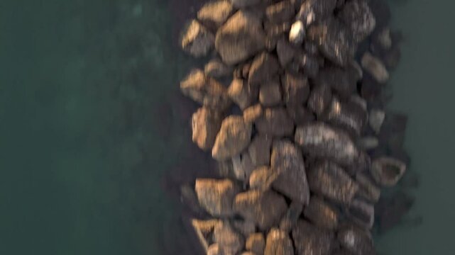 Aerial drone video of the Adriatic Sea at sunrise off Porto Potenza, Italy. Peaceful flyby capturing calm waters, golden reflections, and serene coastal beauty.