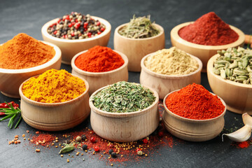 Different aromatic spices on black table, closeup