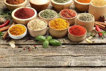 Different aromatic spices on wooden table, closeup. Space for text