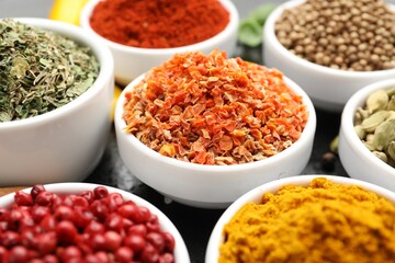 Different aromatic spices in bowls on table, closeup