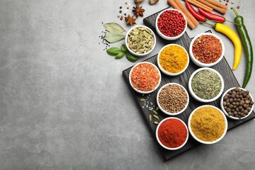 Different aromatic spices on grey table, flat lay. Space for text