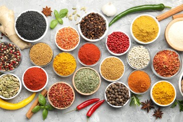 Different aromatic spices on grey table, flat lay
