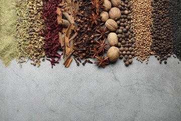 Many different spices on grey table, flat lay. Space for text