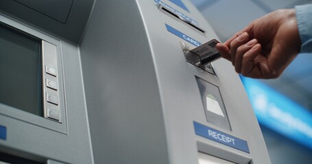 Cash Machine in Airport Terminal: Unrecognizable Person Inserting Plastic Credit Card Into Card Reader Slot for Cash Withdrawal Transaction. Automated Teller Machine, Banking Services. Close Up Shot.