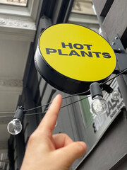 Pointing to a sign that says HOT PLANTS