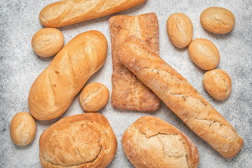 Collection of fresh bread on light grunge background, top view