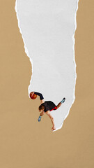 Basketball player jumps high with ball along narrow torn paper stripe on tan background. Paper...