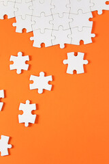 jigsaw puzzle pieces on orange colored background	
