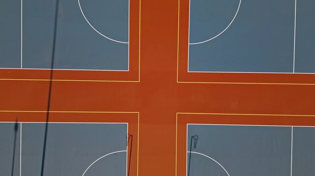 Top view of netball courts in vibrant orange and grey colors