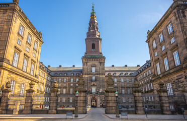 Obraz premium Christiansborg Palace stands majestically on Slotsholmen islet in central Copenhagen. Its stunning architecture and historical significance attract many visitors throughout the year.