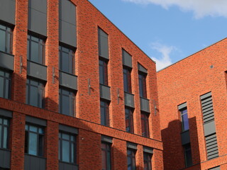 Obraz premium A modern brick building featuring large windows, set against a backdrop of clear skies