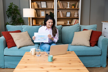 Young freelance business woman having video call conference on laptop computer while sitting and...