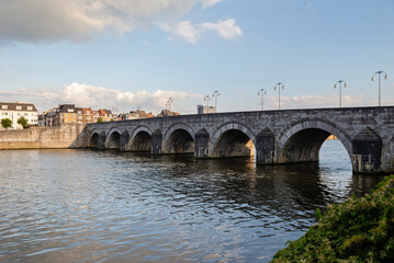 Fototapeta premium Maastricht, Netherlands - September 17, 2024: View of the old stone bridge on the city's waterfront