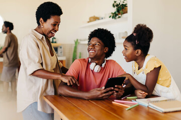 Obraz premium Happy family learning and assisting each other with technology