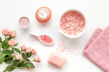 Spa organic cosmetic products with roses essential oil on white background top view