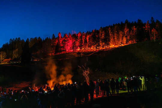 Night view of a dark forest illuminated with red light, under a starry sky. Krampus and St Nicholas, 5 December in Camporosso Valcanale, Tarvisio, Italy.