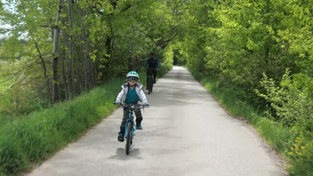Family, parents with children, riding bikes in nature, springtime