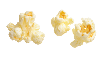 Three pieces of popped popcorn isolated on black background with buttery texture visible closely on transparent background